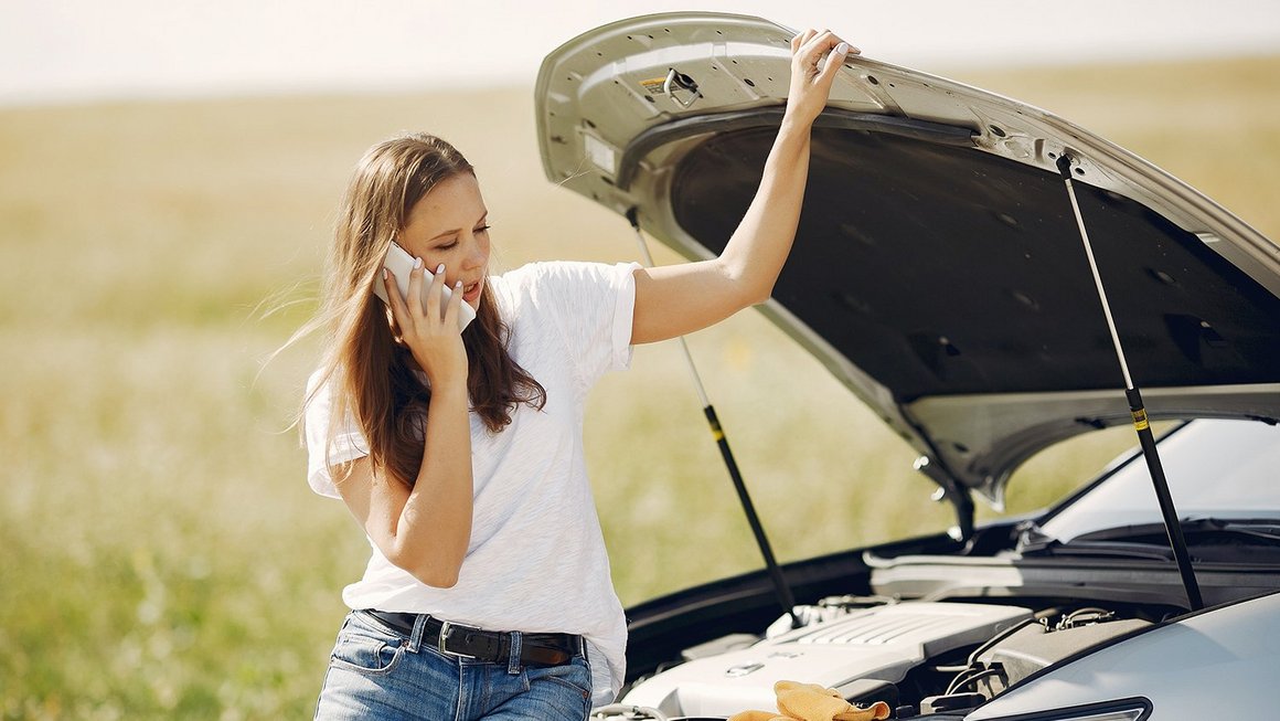 Žena pored ceste ima kvar na automobilu