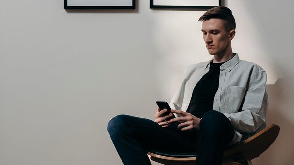 Čovjek zabrinuto gleda u svoj mobilni telefon - rast cijena Čovjek zabrinuto gleda u svoj mobilni telefon - rast cijena