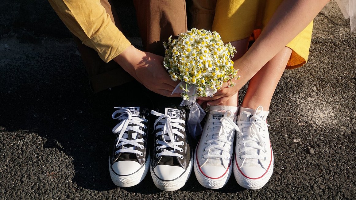 Par sjedi na podu s cvijećem u ruci - Planiranje vjenčanja