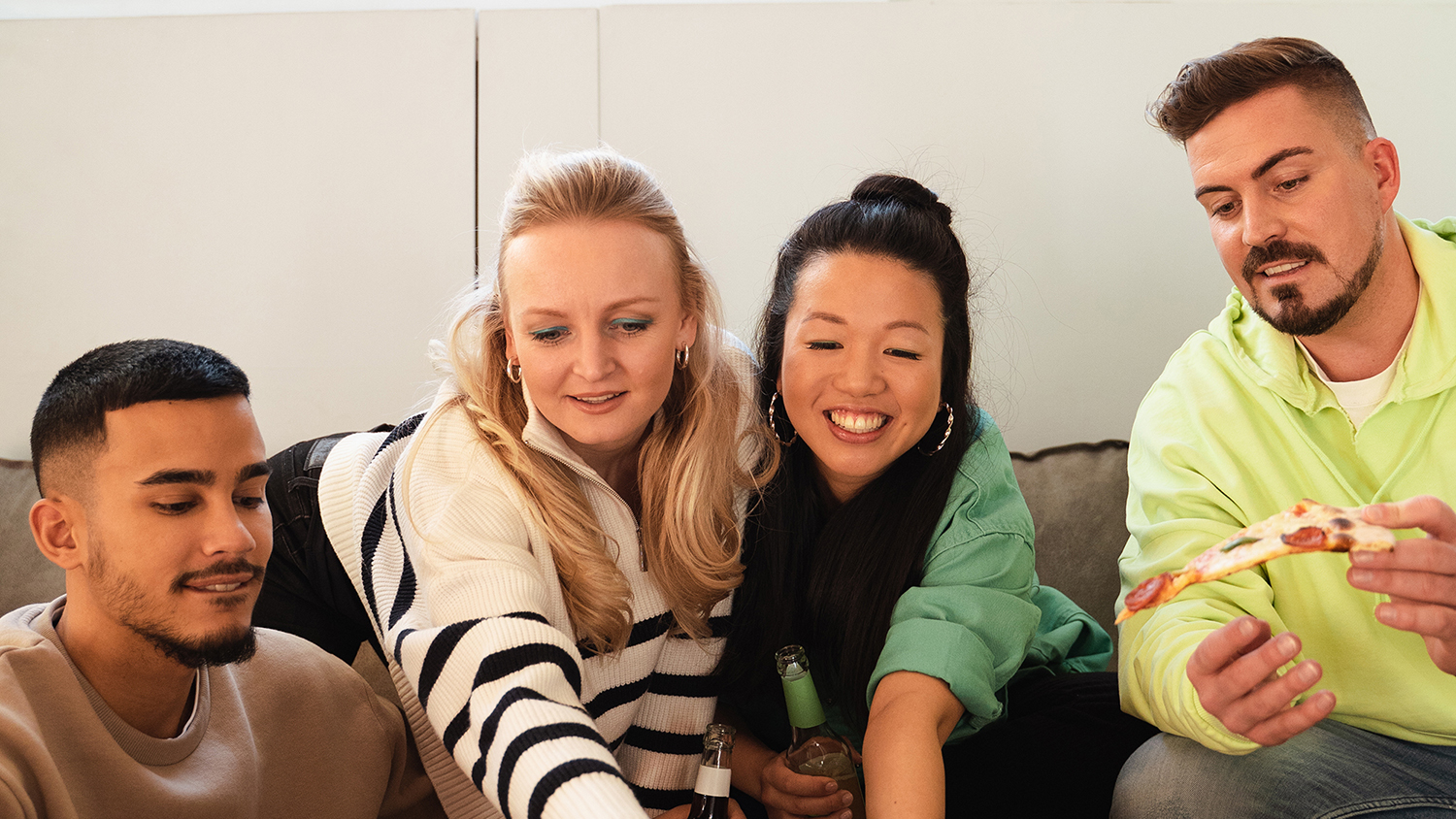 Kako funkcionira zajednički stan? Četvero mladih ljudi sjede zajedno na kauču i smiju se