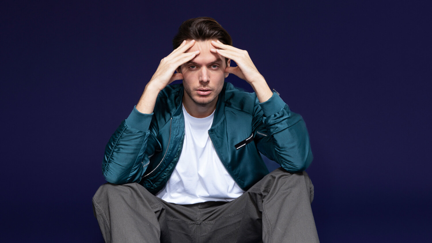 Što je potrošački kredit? Mladić sjedi na podu i zabrinuto drži ruke na glavi