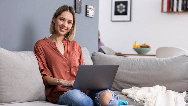 Žena radi na laptopu na svome kauču