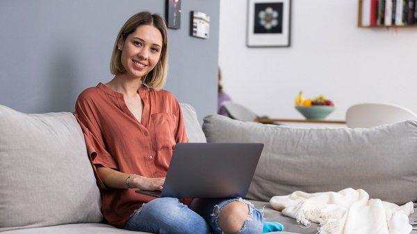 Žena radi na laptopu na svome kauču Žena radi na laptopu na svome kauču